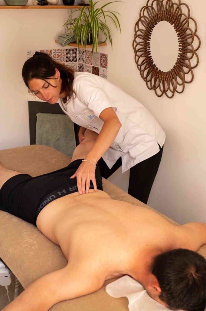 Ostéopathe Laetitia Landais-Maillard réalisant une manipulation du bassin sur un patient adulte allongé.
