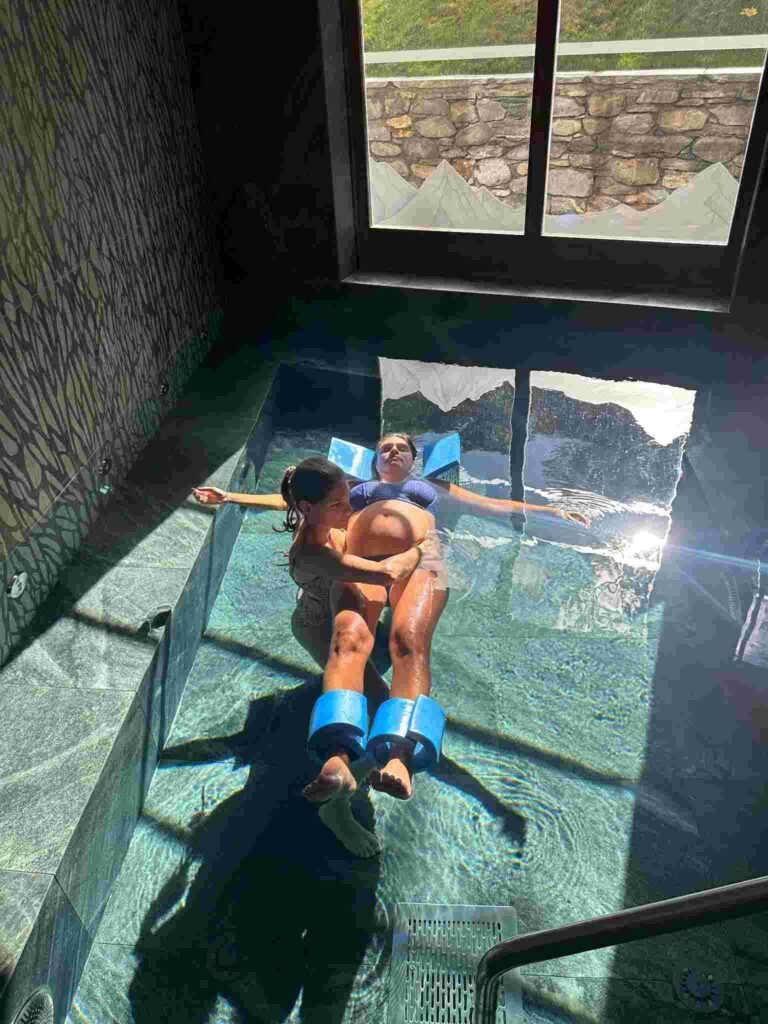 Séance aquatique pour femme enceinte avec Laetitia Landais-Maillard, l’ostéopathe accompagne la future maman flottant dans l’eau avec des flotteurs.